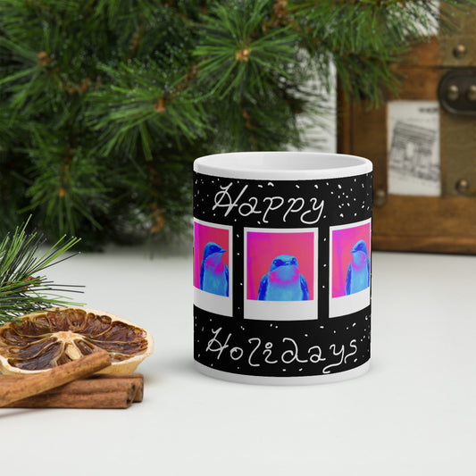 Mug with 'Happy Holidays' text and bird design, placed on a surface with Christmas decorations.