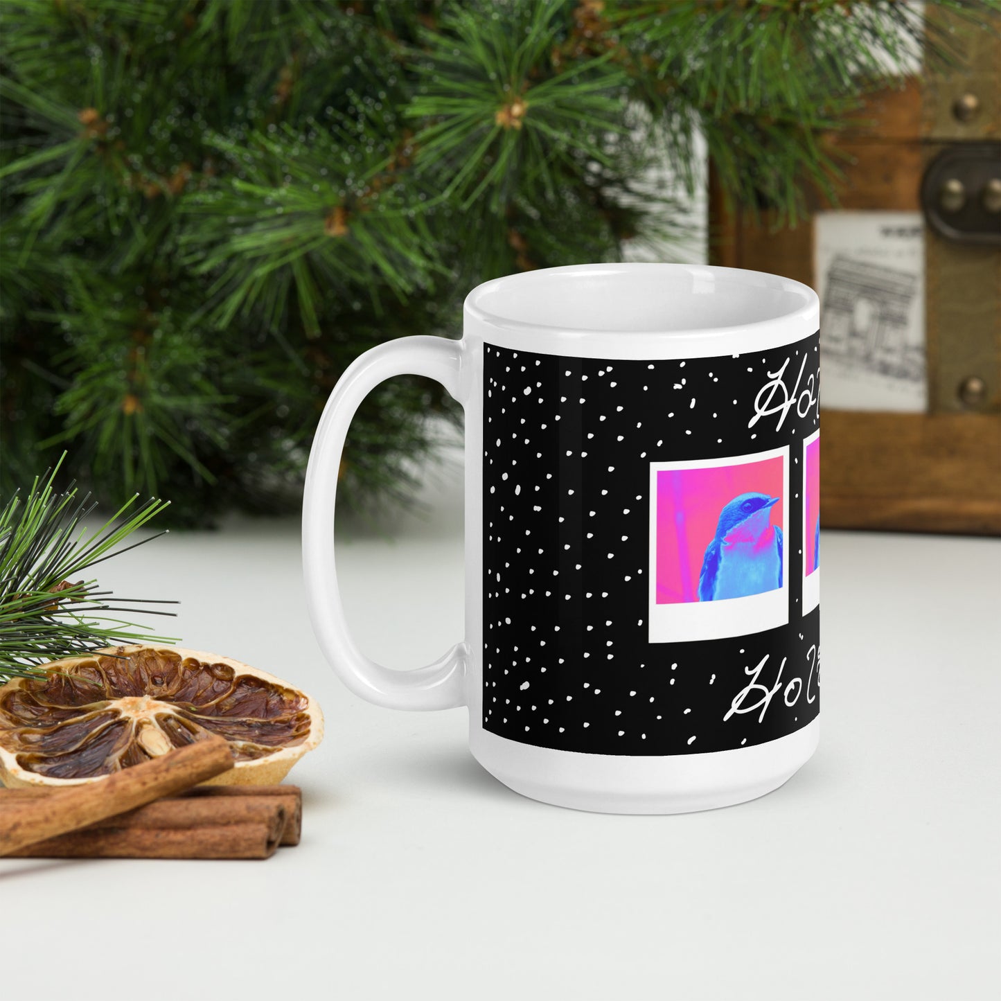 White mug with black design featuring colorful abstract art, placed on a surface with decorative elements.